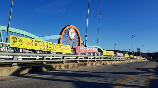 경북 울진 근남면에 추진되는 스마트축산 ICT시범단지 조성 사업과 관련, 반대하는 지역 주민들의 현수막과 단지에 입주하는 축산 농가들의 지지 현수막이 18일 근남면 수산교 양쪽에 걸려 있다.