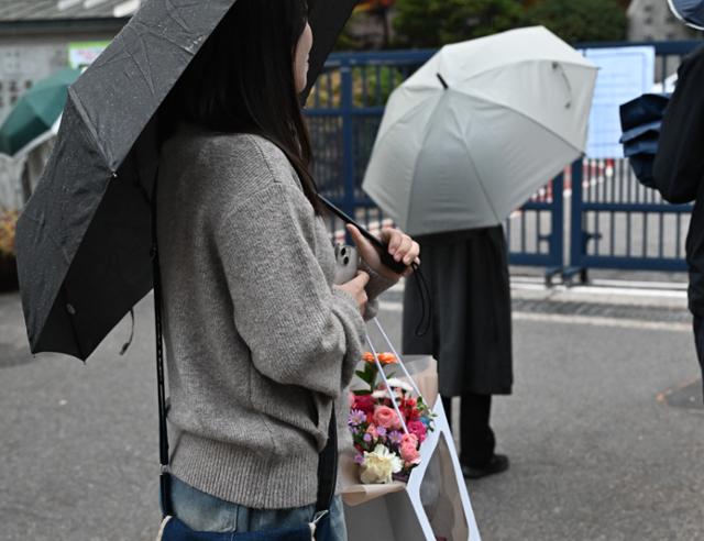 대학수학능력시험이 치러진 14일 서울 종로구 경복고 고사장 앞에서 한 학부모가 꽃다발을 든 채 수험생 자녀가 나오기를 기다리고 있다. 강예진 기자