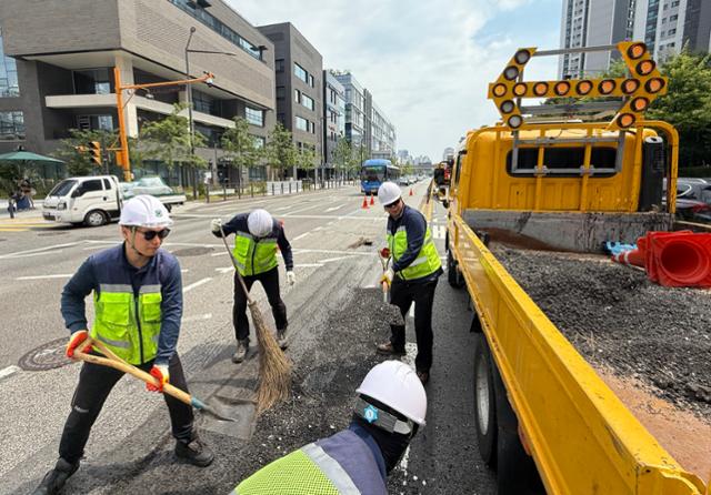 Workers from the Seoul Southern Road Office repair a section of road in Seocho District, Seoul, on July 31 after extreme heat and heavy loads caused it to buckle. Hankook Ilbo