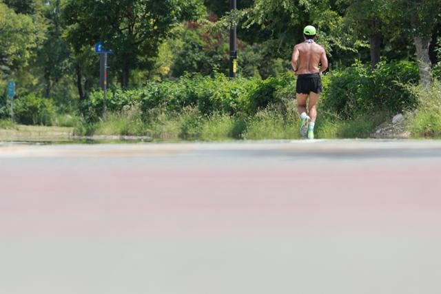 A man runs shirtless near Seogang Bridge in Yeouido, Yeongdeungpo District, Seoul, on Aug. 24 amid continued heatwave conditions. Yonhap
