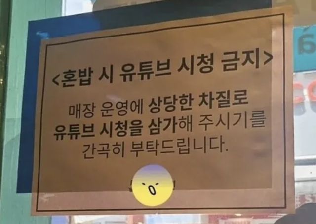 A restaurant notice bans solo diners from watching YouTube while eating. Captured from Thread