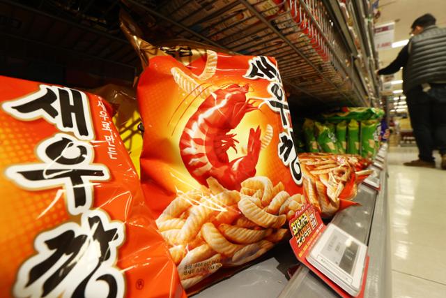 Nongshim Saeukkang and other Korean shrimp and fish shaped snack bags stacked on a large Seoul supermarket shelf