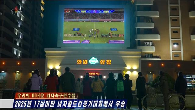 North Koreans watch the FIFA U-17 Women’s World Cup final on large outdoor screens and televisions in Pyongyang as Korean Central Television airs the match. Captured from Korean Central Television