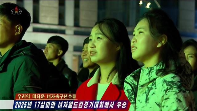 North Koreans watch the FIFA U-17 Women’s World Cup final on large outdoor screens and televisions in Pyongyang as Korean Central Television airs the match. Captured from Korean Central Television