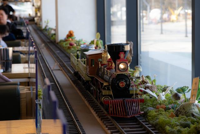 Drinks ordered at the Scenery with a Train cafe are delivered by rail at Hwarangdae Railroad Park in Seoul. Hankook Ilbo