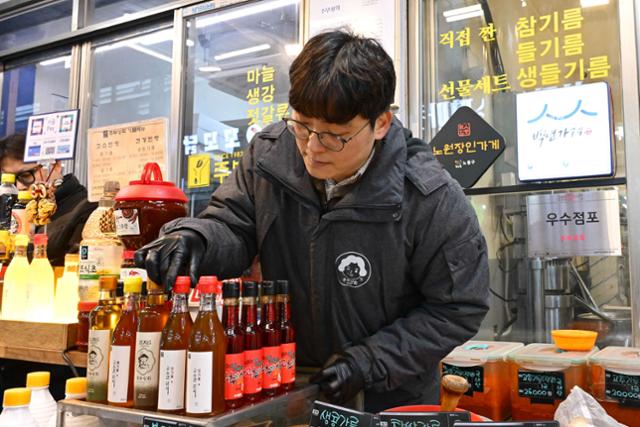 Kim Jong-ho arranges bottles of oil for sale at Jubu Sanghoe in Nowon, Seoul, Monday. Hankook Ilbo