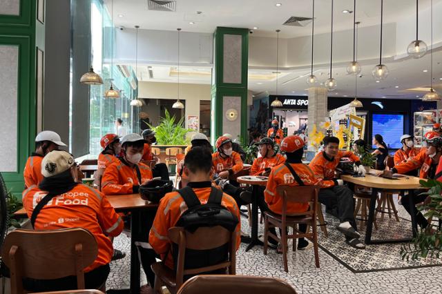 ShopeeFood delivery riders wait to pick up drinks at a Phuc Long coffee and tea shop. Hankook Ilbo
