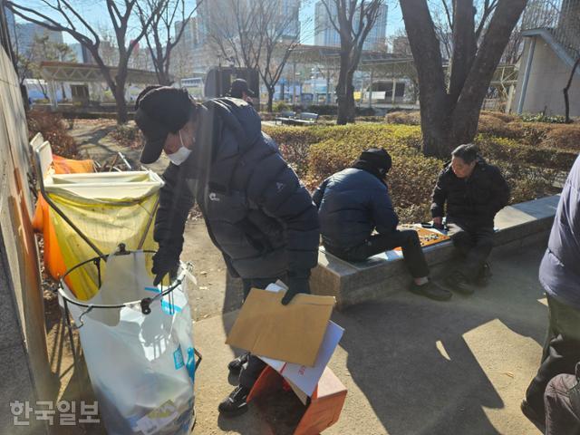 Jo Yong-geun disposes of trash he collected with a litter picker into a garbage bag in Jongmyo Square Park. Korea Times photo by Na Gwang-hyeon 