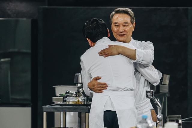 Chef Hou Deok-juk embraces a junior chef after their matchup in 'Culinary Class Wars 2.' Courtesy of Netflix