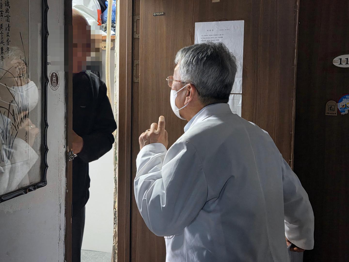 Ko Young-cho, right, director of Joseph Clinic, checks on a resident during a home visit in Dongja-dong, Yongsan District, Seoul, April. 28. Korea Times photo by Na Min-seo
