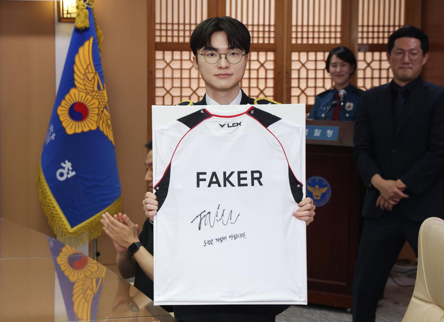 Professional gamer Lee Sang-hyeok, better known as 'Faker,' poses after signing a team jersey during a ceremony appointing him as an honorary police officer and ambassador for a youth cyber gambling prevention campaign at the National Police Agency headquarters in Seoul, Wednesday. Yonhap
